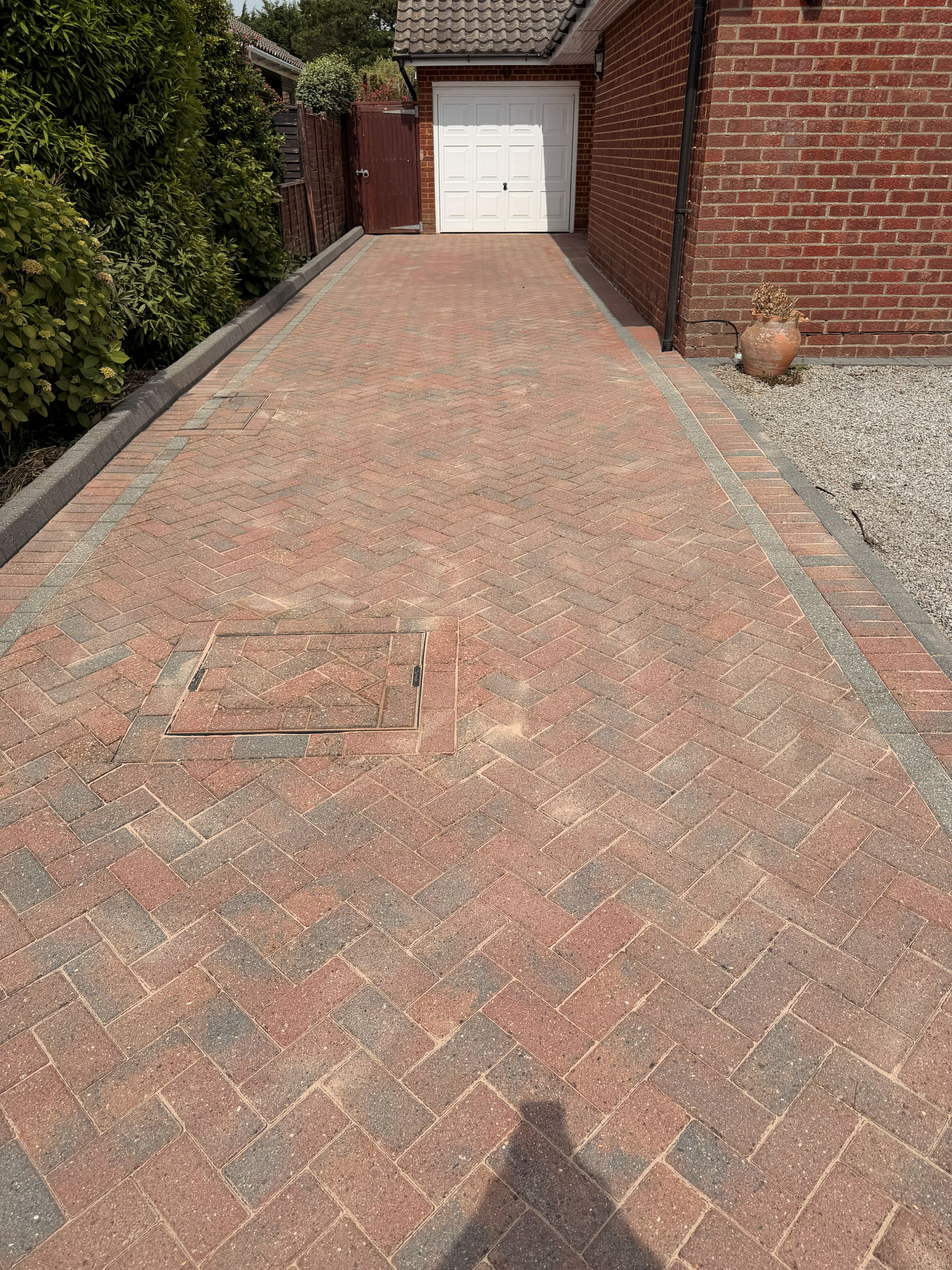 Block paved driveway cleaning result in front of a garage