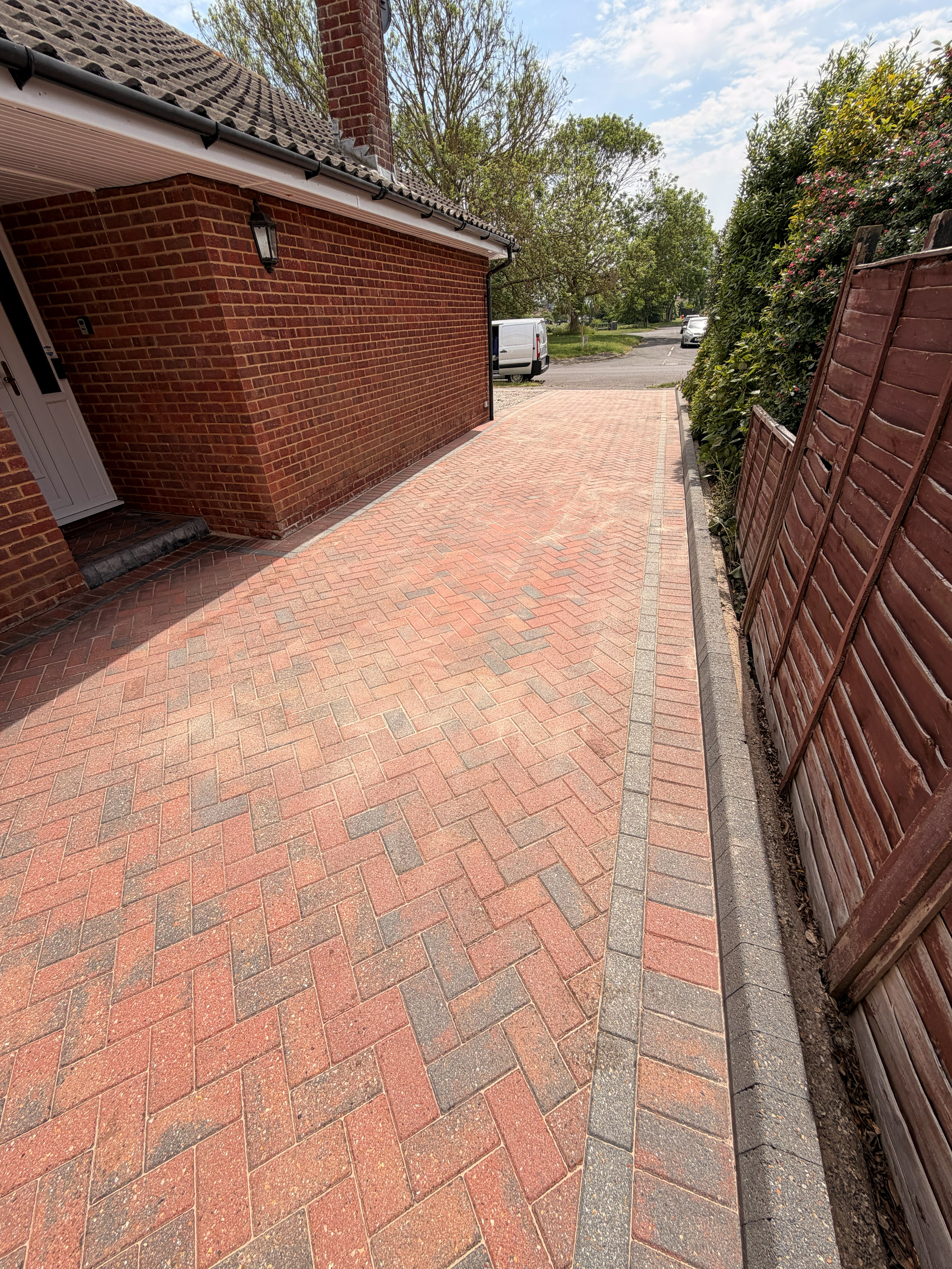 Clean block paved driveway beside a house
